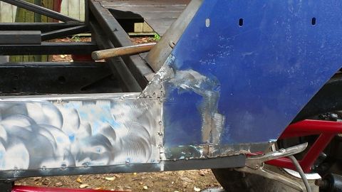 1978 Ford Bronco - Metal repair work in progress on a blue vehicle body panel.