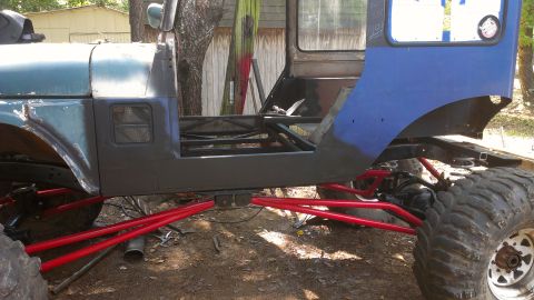 1978 Ford Bronco - This custom off-road vehicle chassis features a striking red suspension system and oversized tires, suggesting significant modifications.