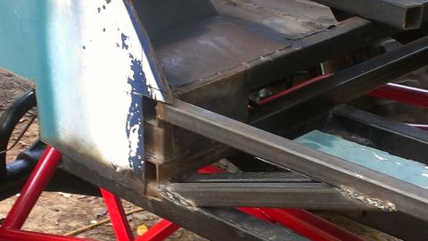 1978 Ford Bronco - The frame of a custom-built vehicle is shown, with parts of its body and structural supports visible.