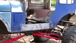 1978 Ford Bronco - A partially restored blue SUV body is visible, with evidence of rust repair and a prominent red roll cage.