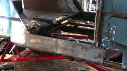 1978 Ford Bronco - The rear frame and chassis of a vehicle undergoing restoration, showing significant rust and repair work.