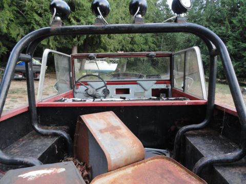 1961 International Scout 80 - View from the rear of an off-road vehicle's interior, a roll cage, roof lights, and a cluttered bed.