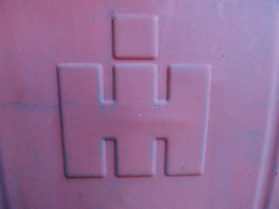 Embossed International Harvester logo on a red surface
