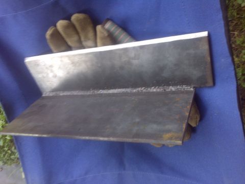 1995 Ford Bronco - A metal part, likely a bracket or reinforcement, is shown after being welded. Gloves are placed underneath.