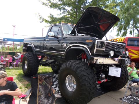1989 Ford Bronco - This modified pickup truck, likely from the early 1980s, has a lifted suspension and oversized tires.