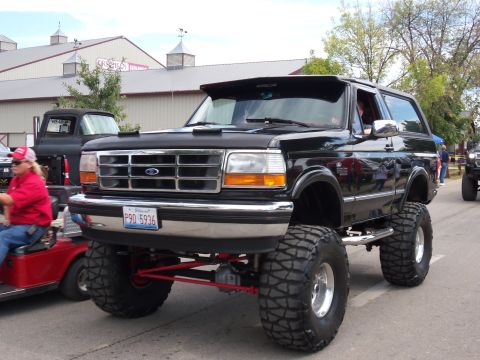 1989 Ford Bronco - This lifted 1992 Ford Bronco features oversized tires and a prominent suspension system, suggesting off-road capabilities.