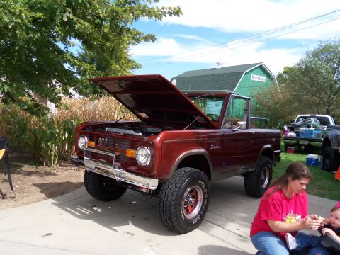 1989 Ford Bronco - A red 1978 Ford Bronco is displayed with its hood open, parked outdoors near a green barn.