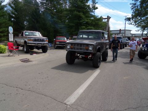 1989 Ford Bronco - A lifted 1978 Ford Bronco is shown driving, with other vehicles present in the scene.