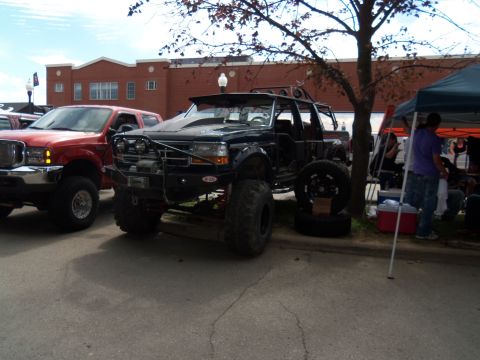 1989 Ford Bronco - Modified 1989 Ford Bronco on display at an outdoor event, alongside a red Ford F-Series truck.
