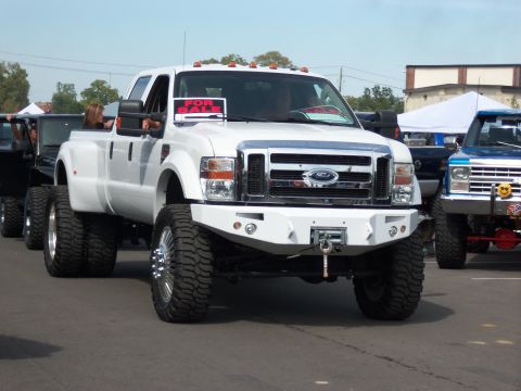 1989 Ford Bronco - A white Ford F-series truck is parked outside with a 'For Sale' sign visible in the windshield.