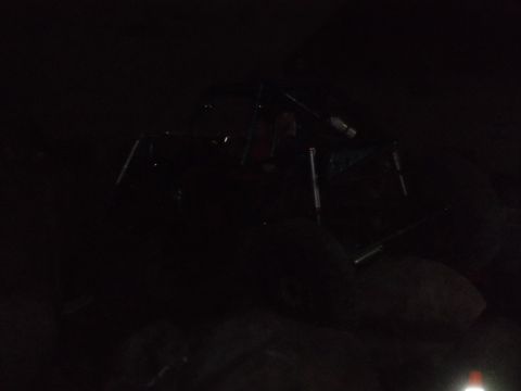 1989 Ford Bronco - An off-road vehicle is barely visible in the darkness, with only its frame and tires discernible.