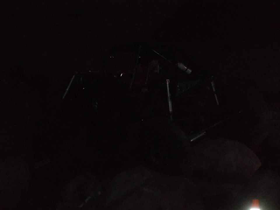 Dark scene with a partially visible off-road vehicle frame and tires