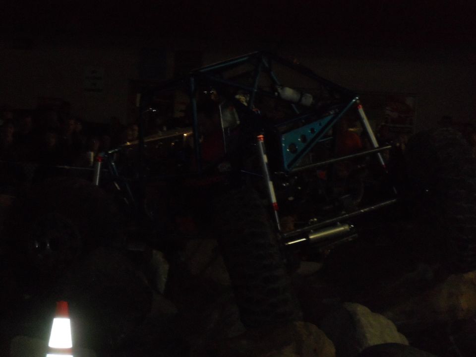Custom buggy with roll cage and large tires on rocks at night