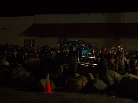 1989 Ford Bronco - A custom-built off-road buggy is positioned on rocks in front of a crowd at night.
