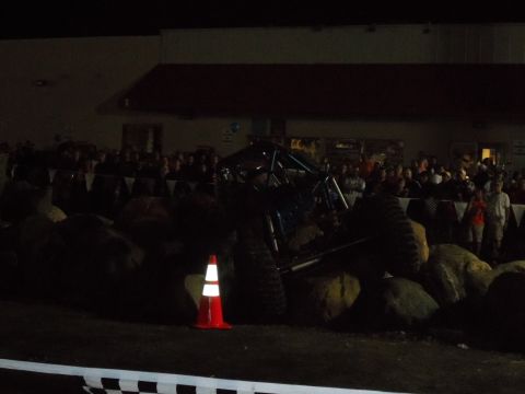 1989 Ford Bronco - A blue off-road buggy navigates a rock obstacle course under artificial lights.