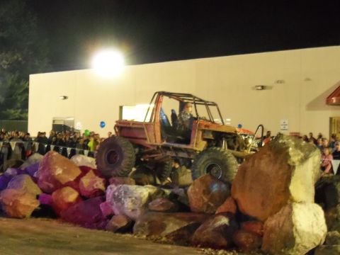 1989 Ford Bronco - A heavily modified off-road vehicle navigates a rock obstacle course in front of a crowd.
