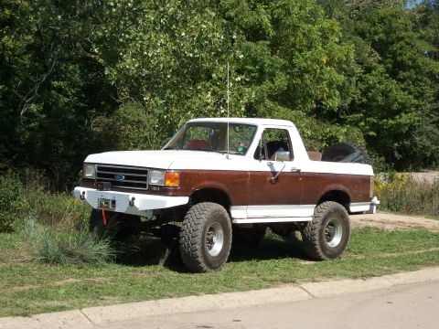 1989 Ford Bronco - This lifted 1989 Ford Bronco features a two-tone paint scheme and a custom front bumper.