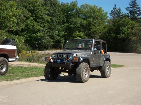 1989 Ford Bronco - A Jeep Wrangler Rubicon is seen on the road with another vehicle parked nearby.