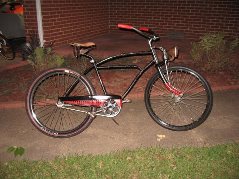 1994 Ford Bronco - A black cruiser bicycle with red accents sits parked on a sidewalk.
