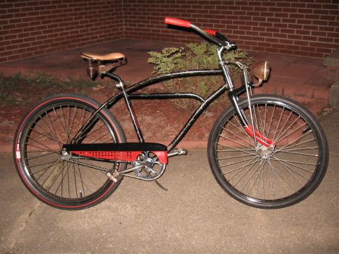 1994 Ford Bronco - A vintage-style cruiser bicycle with a black frame and red trim is parked outdoors.