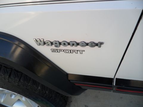 1994 Jeep Cherokee - Close-up of the 'Wagoneer SPORT' badge on the side of a white Jeep.