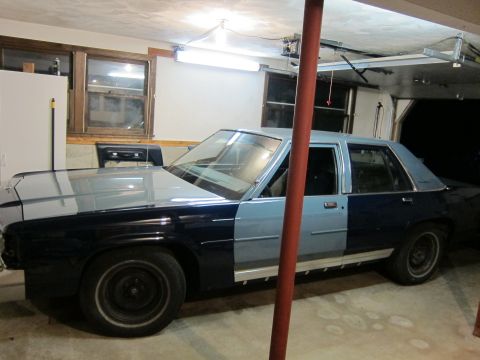 1991 Ford LTD Crown Victoria - This Ford Crown Victoria appears to be undergoing a paint job, with two distinct colors on its body panels.
