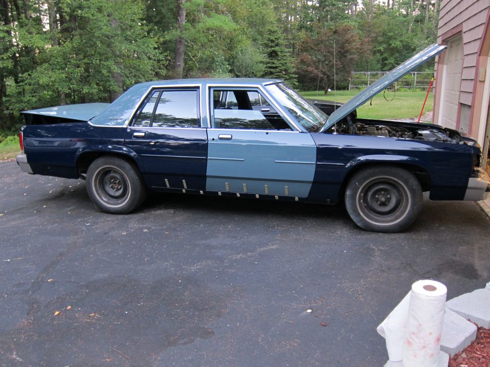1991 Ford Crown Victoria with hood open, showing two-tone paint job and various body panels