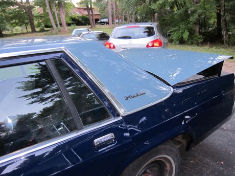 1991 Ford LTD Crown Victoria - The "Crown Victoria" badging on this dark blue sedan with a light blue vinyl roof confirms it is a 1991 Ford Crown Victoria LTD.
