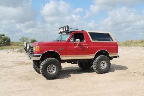 1990 Ford Bronco - This lifted 1990 Ford Bronco features auxiliary lights on the roof and front bumper, ready for off-road adventures.