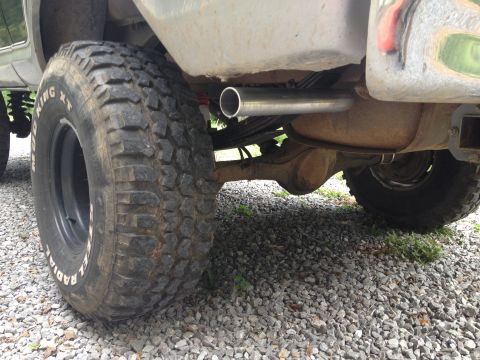 1979 Ford Bronco - Close-up view of the rear tire and exhaust system of a vehicle.