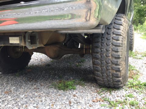 1979 Ford Bronco - Rear axle and tire assembly of a truck, showing the leaf springs and exhaust pipe.