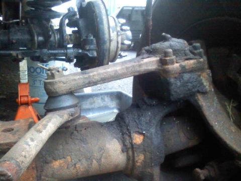 1993 Ford F-150 - This image shows a close-up of a truck's suspension and steering components, with a jack stand visible.