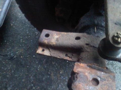 1993 Ford F-150 - Close-up view of a rusty metal bracket, likely part of a vehicle's suspension system.