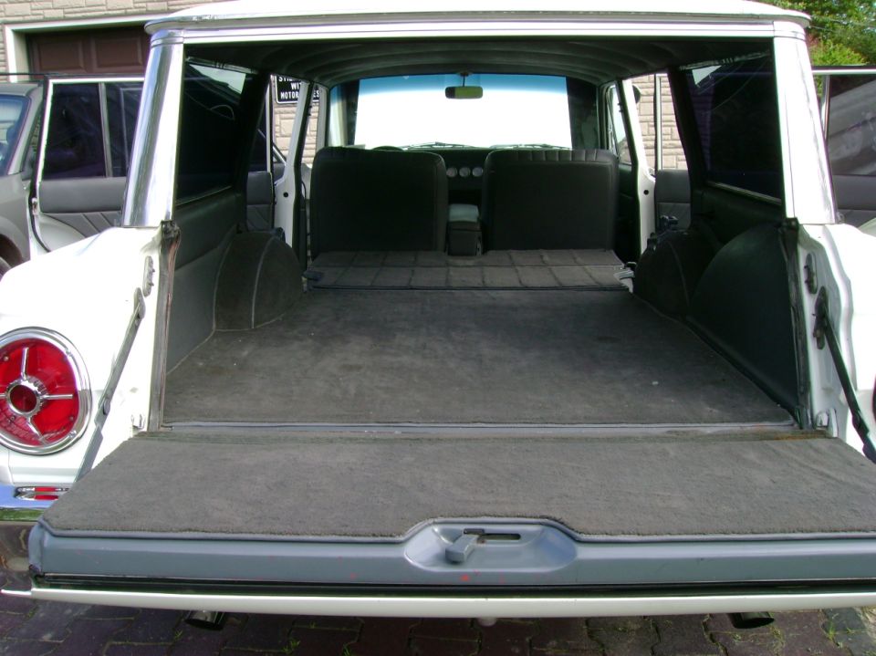 1965 Ford Falcon station wagon rear interior with folded-down seats and carpeted cargo area