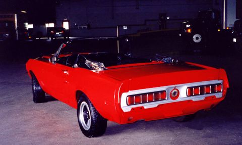 1968 Shelby GT350 - Rear view of a red convertible muscle car, likely a 1969 model, with unique taillight design.