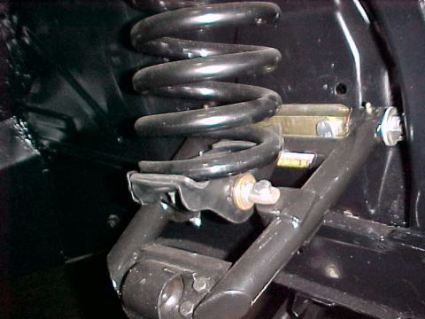 1968 Shelby GT350 - Close-up of a vehicle's suspension system, showing a coil spring and control arm components.