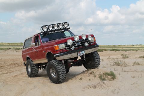 1990 Ford Bronco - This lifted 1990 Ford Bronco is equipped with numerous auxiliary lights and a roof rack, ready for off-road adventures.