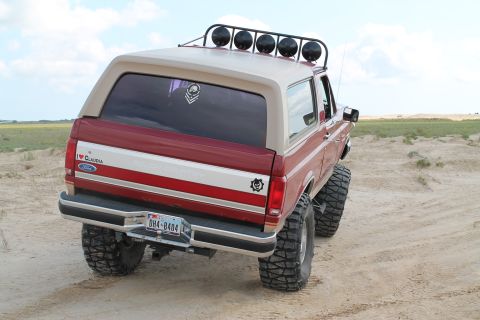 1990 Ford Bronco - This lifted Ford Bronco is ready for off-road adventures with its large tires and roof-mounted light bar.