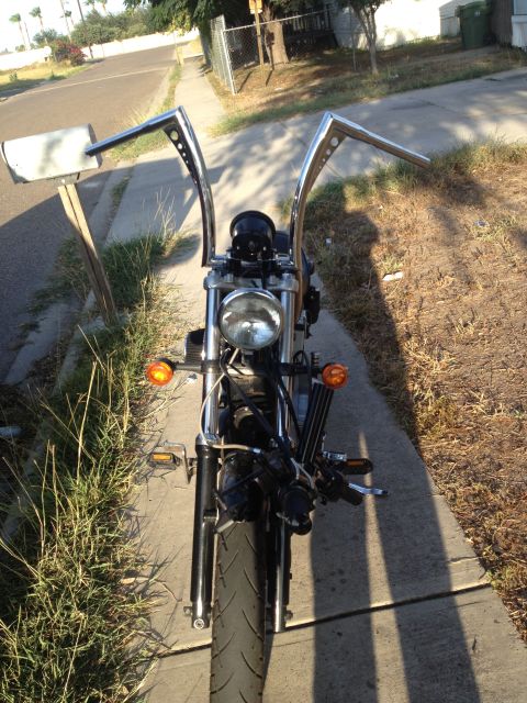 1995 Ford Bronco - Front view of a motorcycle tall chrome handlebars and a single round headlight.