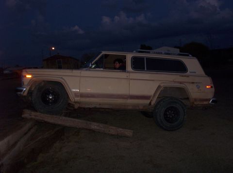 1988 Ford Bronco - This tan SUV with a red stripe is seen from the side as dusk settles.
