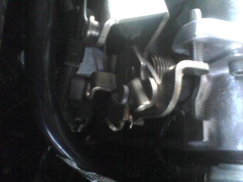 2003 Ford Crown Victoria - A detailed view of a vehicle's throttle linkage mechanism.