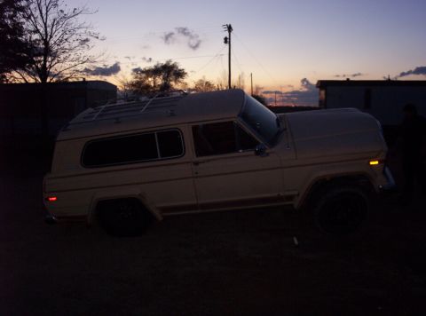 1988 Ford Bronco - Full-size SUV with a camper shell parked outside at dusk.