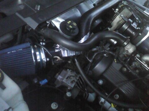 2003 Ford Crown Victoria - Close-up view of an engine bay an aftermarket air intake system and various engine parts.