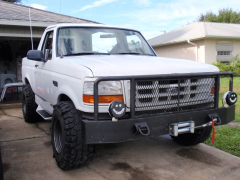 1995 Ford Bronco - This modified Ford Bronco features a winch and off-road tires, suggesting a model year around 1992 based on its body style.