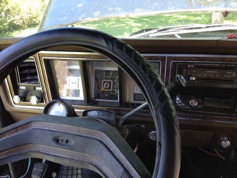 1979 Ford Bronco - The interior of a 1979 Ford Bronco shows its dashboard with analog gauges and wood grain accents.