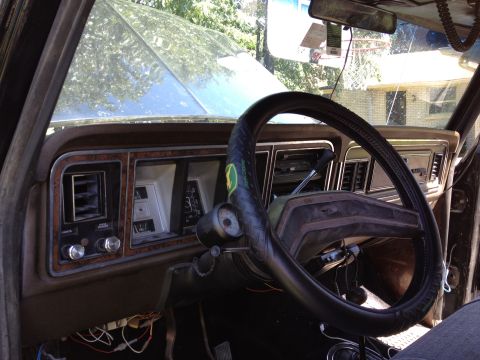 1979 Ford Bronco - The interior of a 1979 Ford Bronco shows its dashboard with wood grain accents and various gauges.