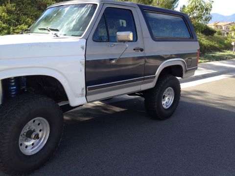 1986 Ford Bronco - This Ford Bronco appears to be from the early 1980s, not 1986, with a two-tone paint scheme and lifted suspension.
