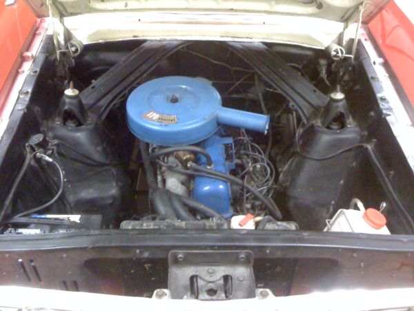 Engine bay with blue 170 air cleaner on inline-six engine in a red vehicle