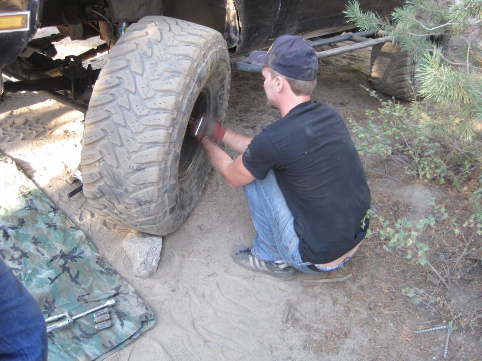 Guy working on a big off-road tire, looks like he's changing it