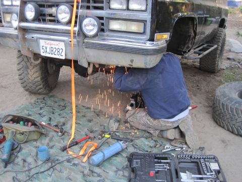 1989 Ford Bronco - Welding sparks fly as someone works on the undercarriage of a pickup truck.